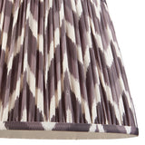 Endon Daneton 35cm tapered lamp shade in pearl grey pleated faux silk with a zigzag print and taped edge detailing, shown close-up.
