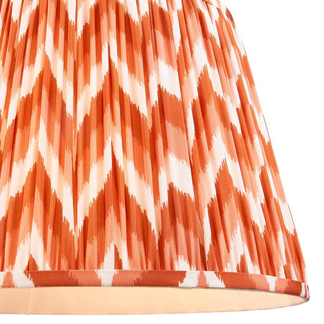 Endon Daneton 40cm tapered lamp shade in apricot orange and white, showing the pleated faux silk with a graphic zigzag print and taped lower edge.
