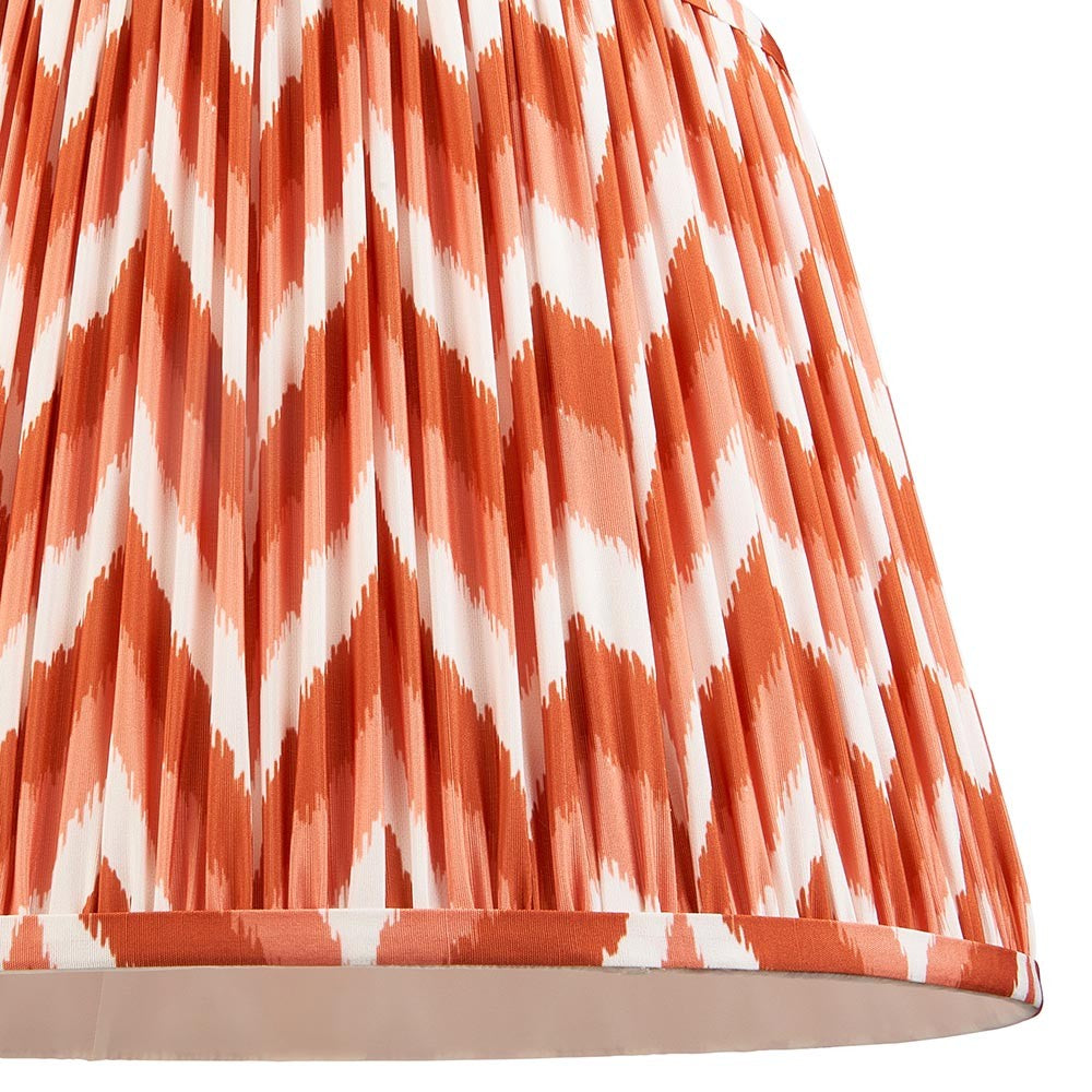 Endon Daneton 40cm tapered lamp shade in apricot orange and white, close-up of the pleated faux silk with zigzag print and taped edge trim.