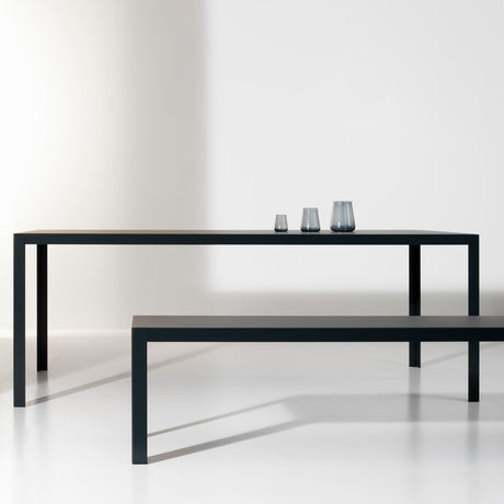 Dats Aluminium Garden Bench in matte black, slim rectangular frame with four straight legs, shown with a matching table in a plain white studio setting.