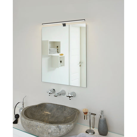 Dervette LED Bathroom Wall Light 60cm in black, fitted above a rectangular mirror in a bathroom with a stone basin and chrome taps.