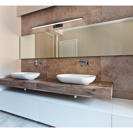 Dervette LED Bathroom Wall Light 78cm in black, a slim bar fixture with white diffuser on a central bracket, mounted above a mirror over a double-sink vanity.