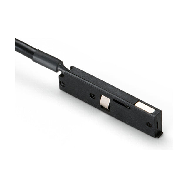 Deva 24V Track Power Feed in black, a slim rectangular connector with a black cable lead, screw fixing points, and metal contacts, shown on a plain white background.