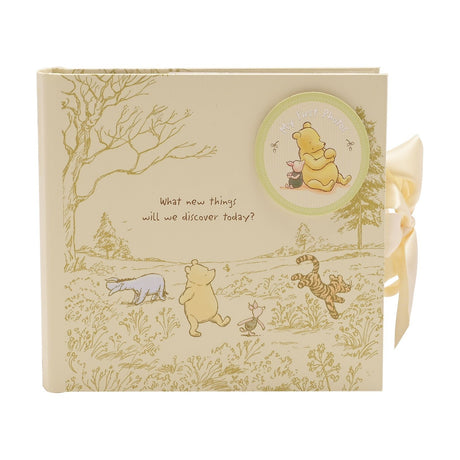 Classic Pooh My First Photos Portrait Album, 6x4in, cream cover with gold line art of Pooh, Piglet, Tigger and Eeyore, green medallion and ribbon tie.