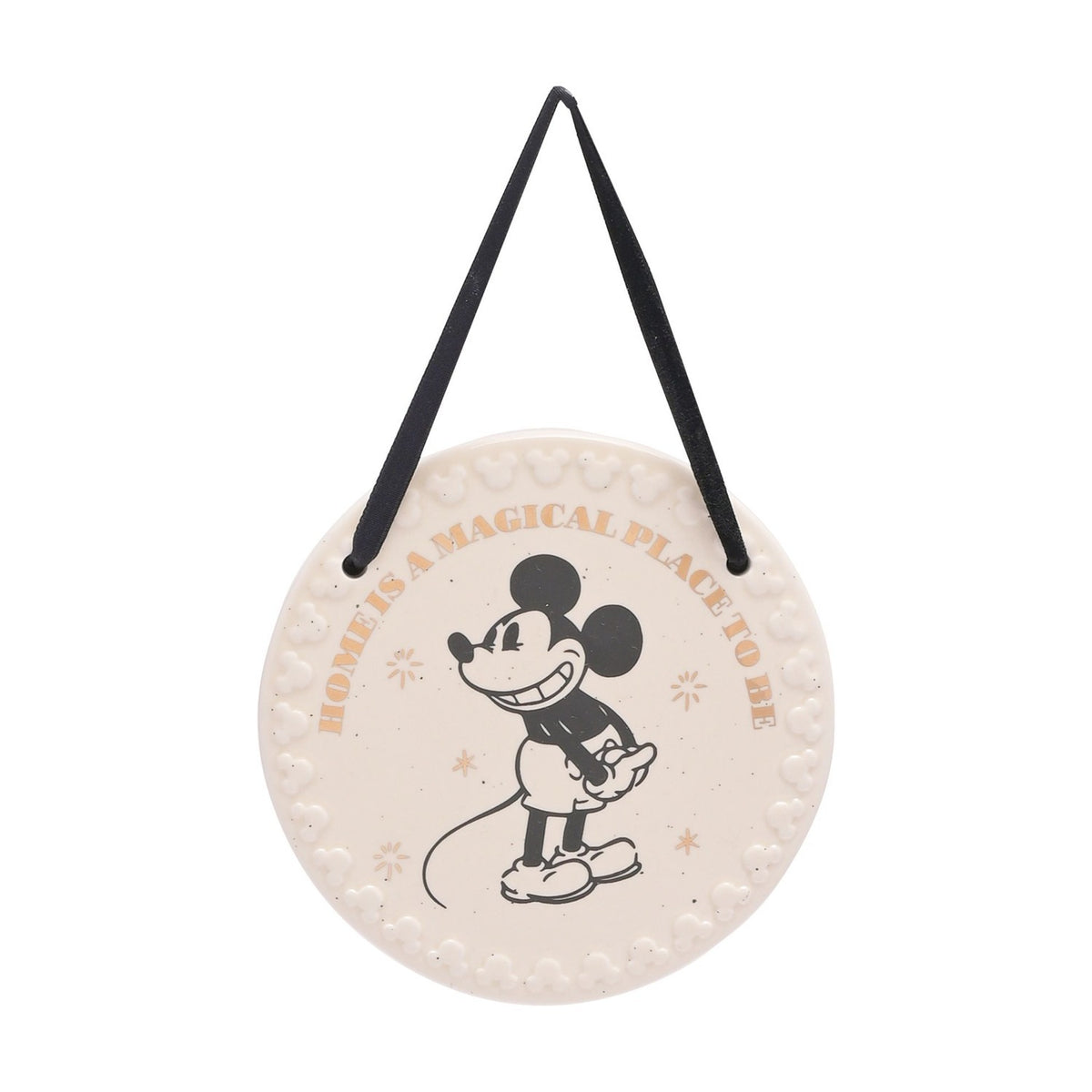 Round white ceramic wall plaque with a black Mickey Mouse illustration, gold "Home is a magical place to be" text, embossed Mickey head border, and black ribbon hanger on a plain background.