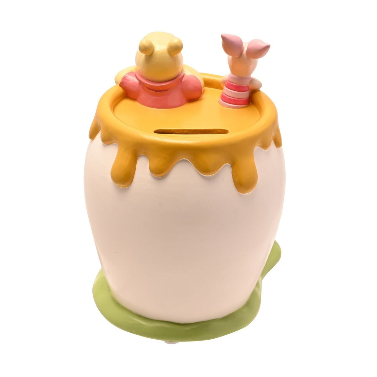 Resin honey pot money box in white with Winnie the Pooh and Piglet peeking over the dripping honey-yellow rim, set on a green grass base, shown on a plain white background.
