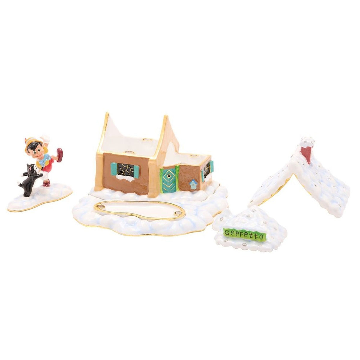 Metal trinket box featuring a snow-covered cottage with tan walls, teal shutters and door, red chimney, a Geppetto sign, and Pinocchio with Figaro figures nearby.