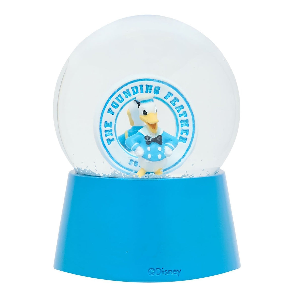 Resin snow globe with a Donald Duck sailor figure in blue uniform inside "The Founding Feather" badge, set on a blue base, plain white background.