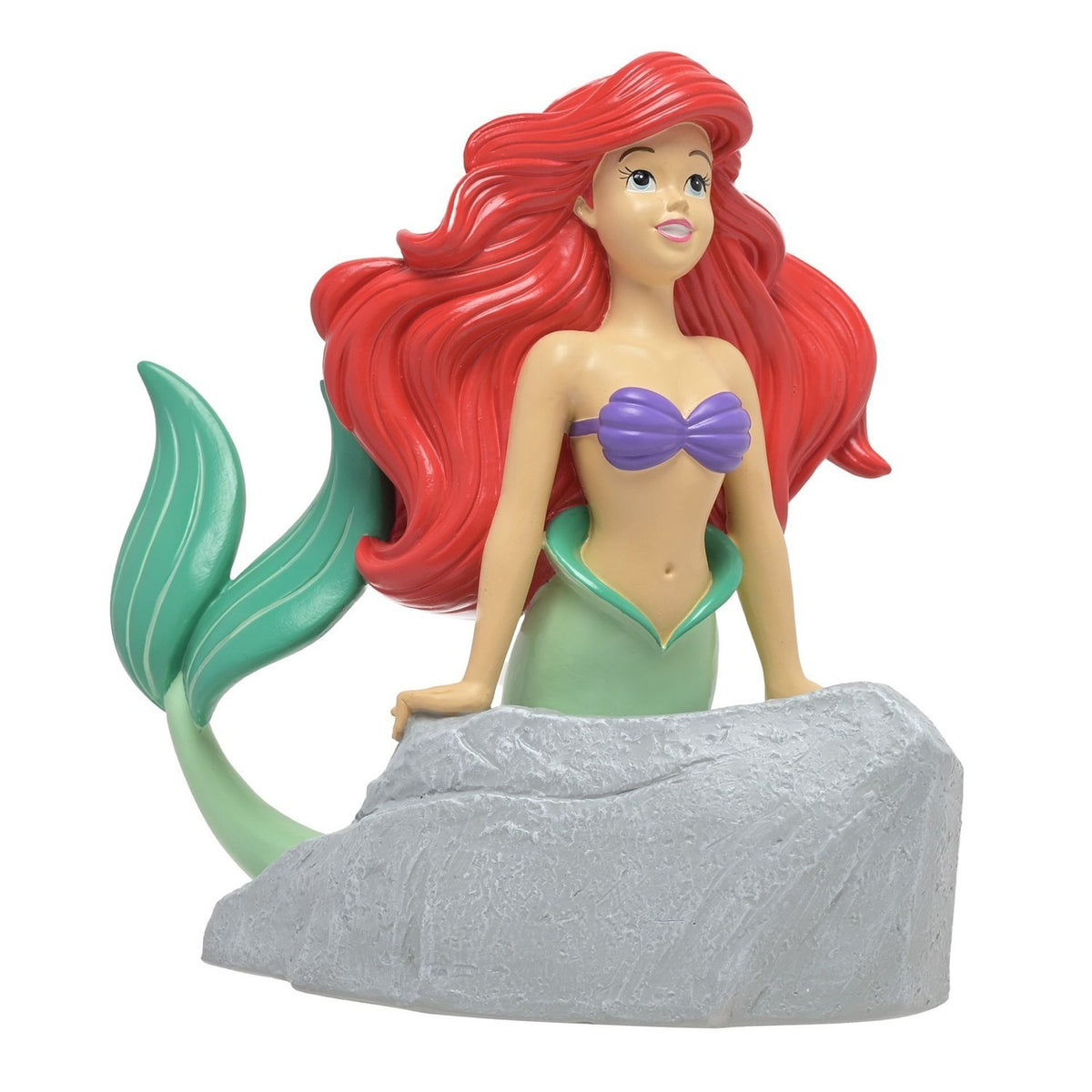 Resin money box featuring Ariel the mermaid with flowing red hair and purple seashell top, leaning on a textured grey rock with coin slot, green tail curling behind, on a plain white background.