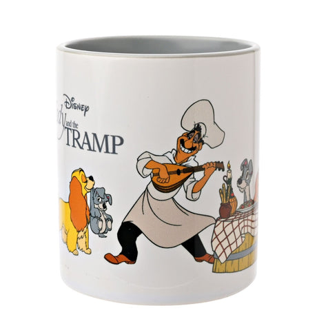 White stoneware mug with grey handle featuring Lady and the Tramp artwork, showing the chef playing mandolin beside a table with the two dogs, on a plain background.