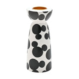 Ceramic tealight candle holder with scattered black Mickey Mouse head shapes on a white speckled finish, rounded cup with gold-coloured insert, narrow waist and tapered base, on a plain background.