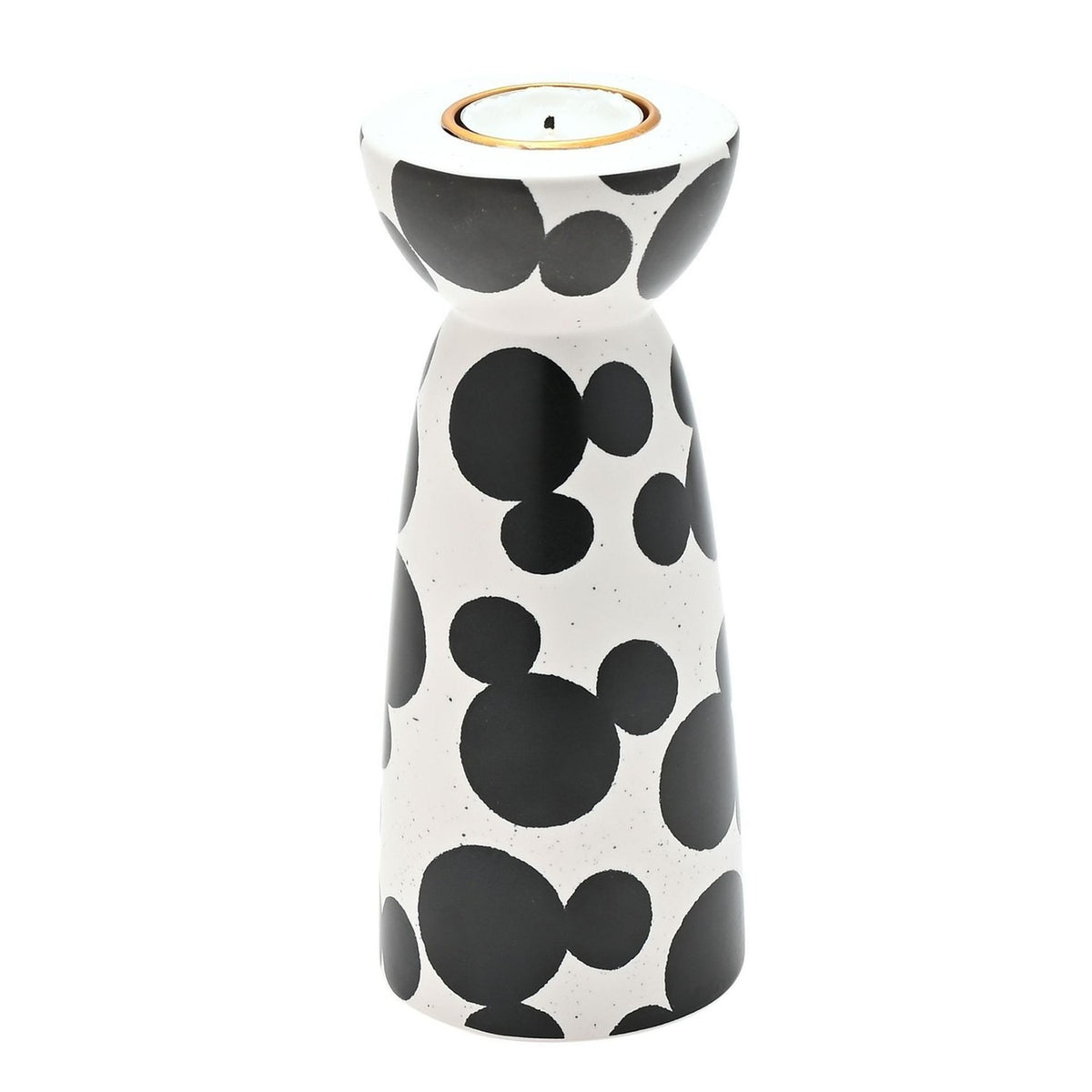 Ceramic tealight candle holder in white with black Mickey Mouse head shapes, rounded cup top with gold-toned insert, narrow waist, and flared base, on a plain white background.
