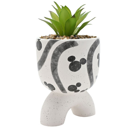 Ceramic planter with arched footed base in speckled white, featuring grey Mickey Mouse head motifs and swirl patterns, holding a faux green plant, on a plain white background.