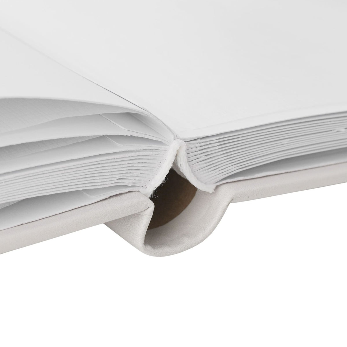 Close-up of the Dumbo Photo Album's grey cover showing bound white pages and cream spine binding with visible stitching, photographed on a plain background.
