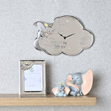 Silver cloud-shaped wall clock featuring Dumbo in relief, embossed stars, and DREAM big little one text, displayed above a shelf with a matching photo frame and Dumbo figurines in a nursery.