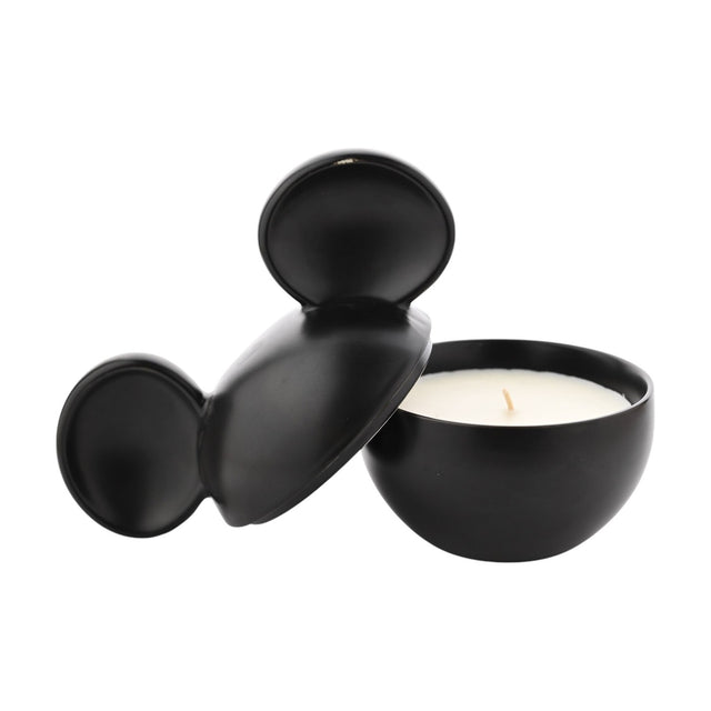 Mickey Mouse ceramic vessel scented candle in matt black, round bowl with white wax and wick, lid with two ear shapes resting beside it, on a plain white background.
