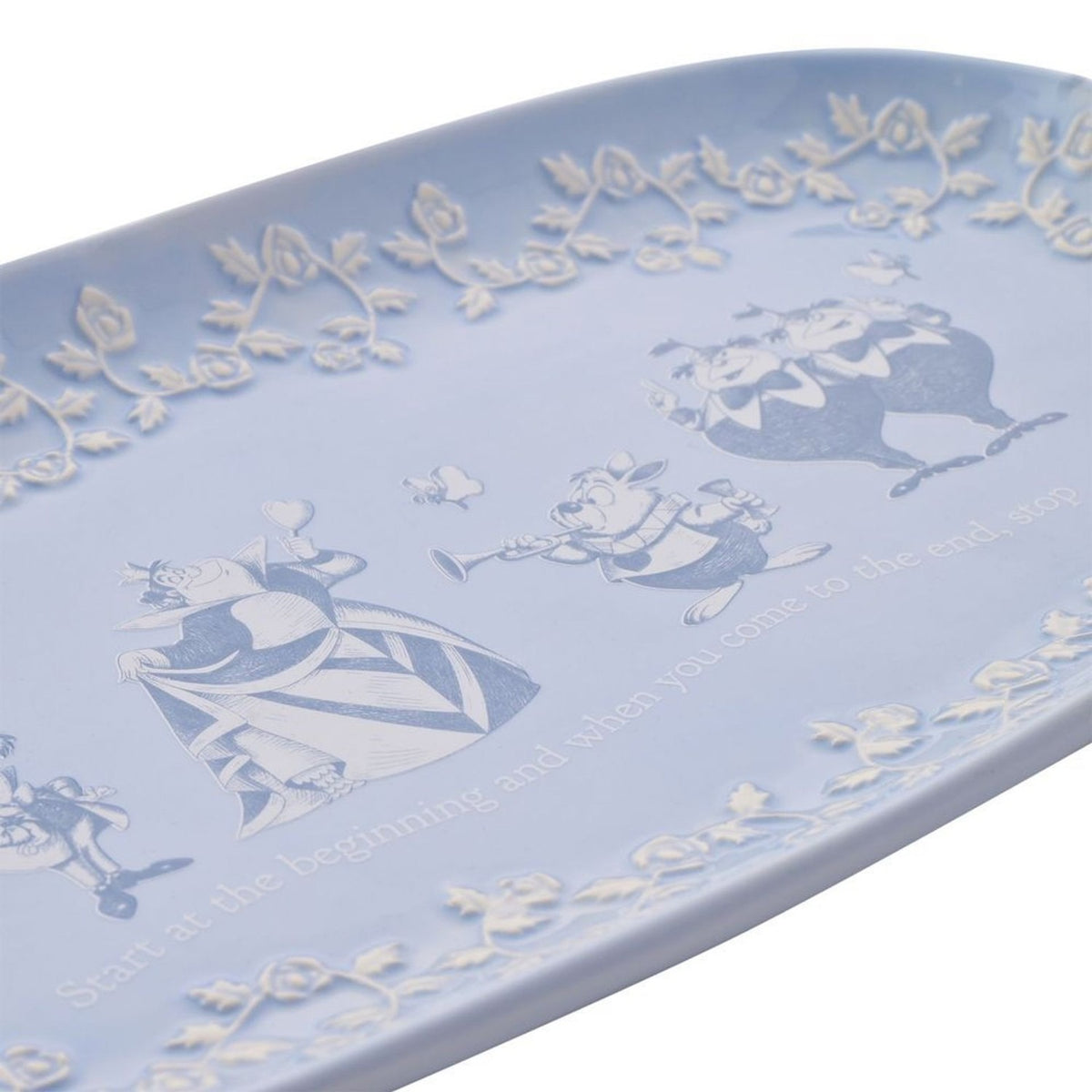 Soft blue glazed earthenware serving plate featuring Queen of Hearts, White Rabbit with trumpet, and Tweedledum and Tweedledee in white and blue line art with a rose-vine border.