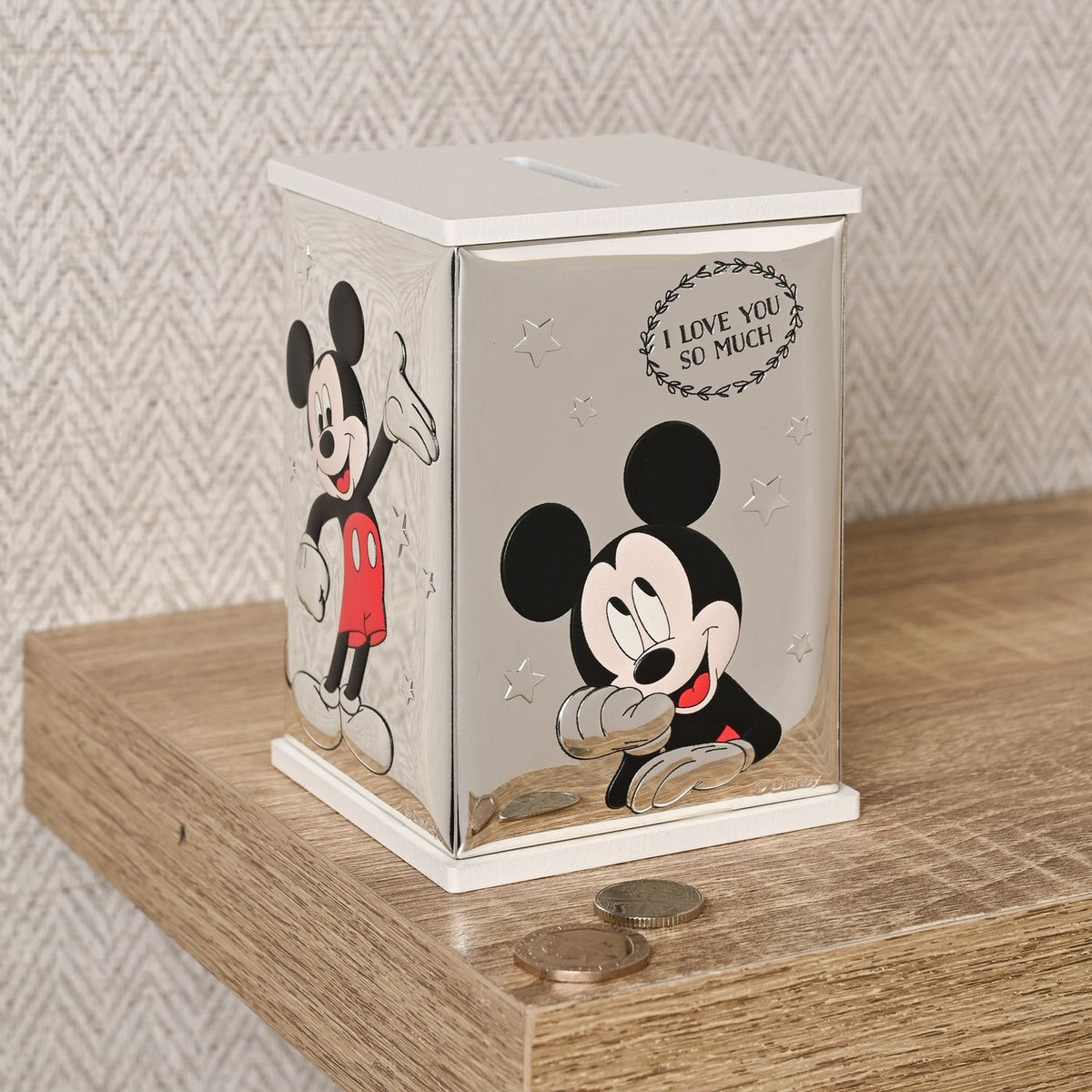 Rectangular Mickey Mouse wooden money box with silver-plated sides, white top and base, and colour illustrations of Mickey waving and resting his chin on his hands.