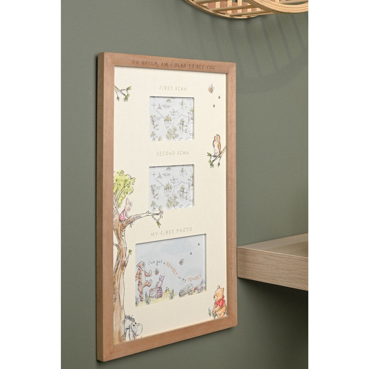 Winnie the Pooh multi aperture scan frame in brown wood with off-white mount, three labelled openings for first scan, second scan and first photo, shown mounted on a green wall.