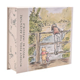 Cream rectangular Winnie the Pooh keepsake box featuring a watercolour print of Pooh, a friend and a boy at a wooden bridge, with spine text "Without Pooh, the adventure would be impossible."