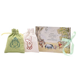 Winnie the Pooh keepsake box set with cream photo album featuring watercolour woodland scene, plus green Eeyore and cream Piglet drawstring bags, on white background.