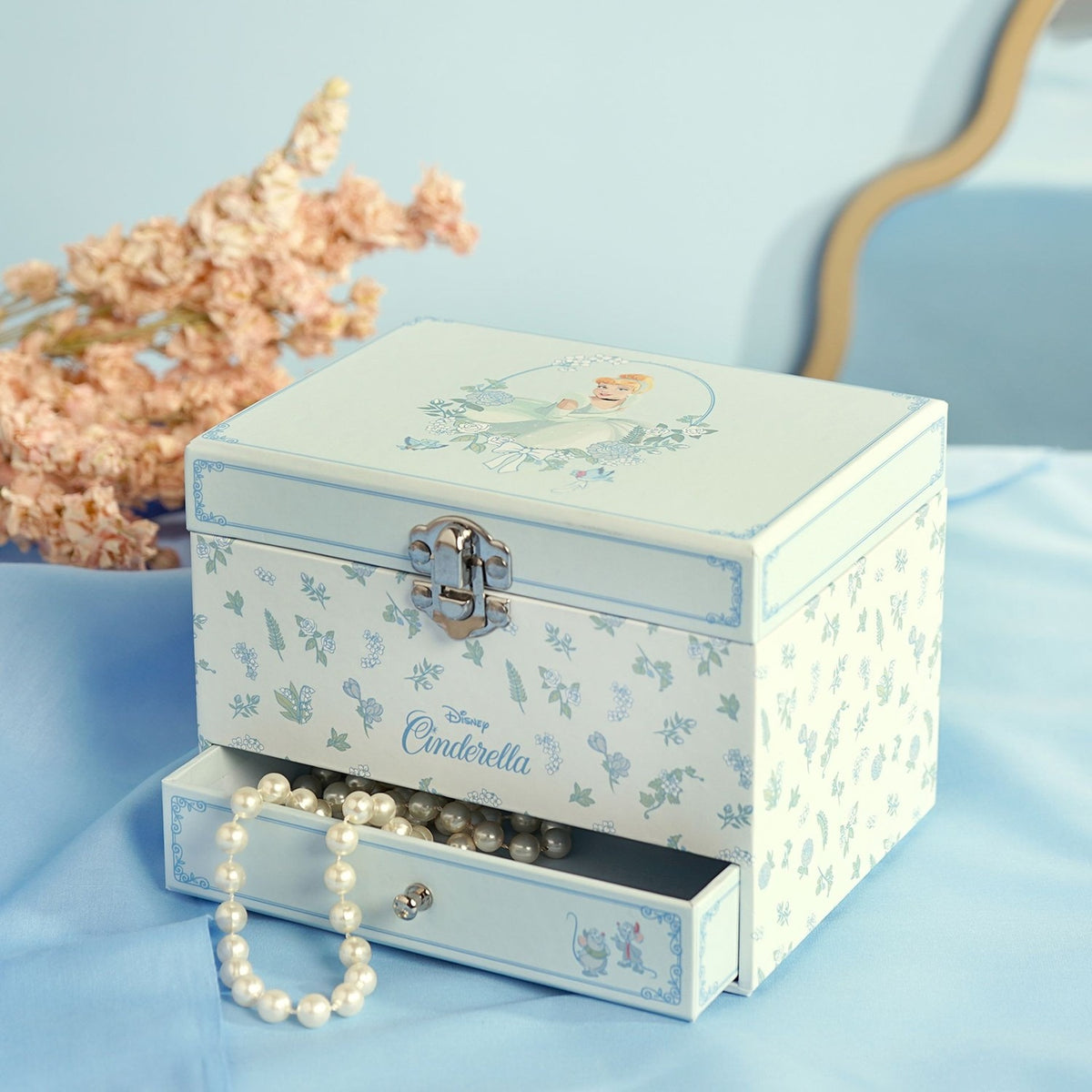 Pastel Princess Cinderella Musical Jewellery Box with Drawer, rectangular white box with floral print and silver clasp, open drawer showing pearl beads, styled beside dried pink flowers.