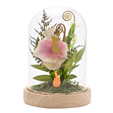 Arched glass cloche on a wood base with pink and white florals, green foliage, gold spiral curls, a gold princess decal reading Let Your Heart Sing, and a small orange flame figure.