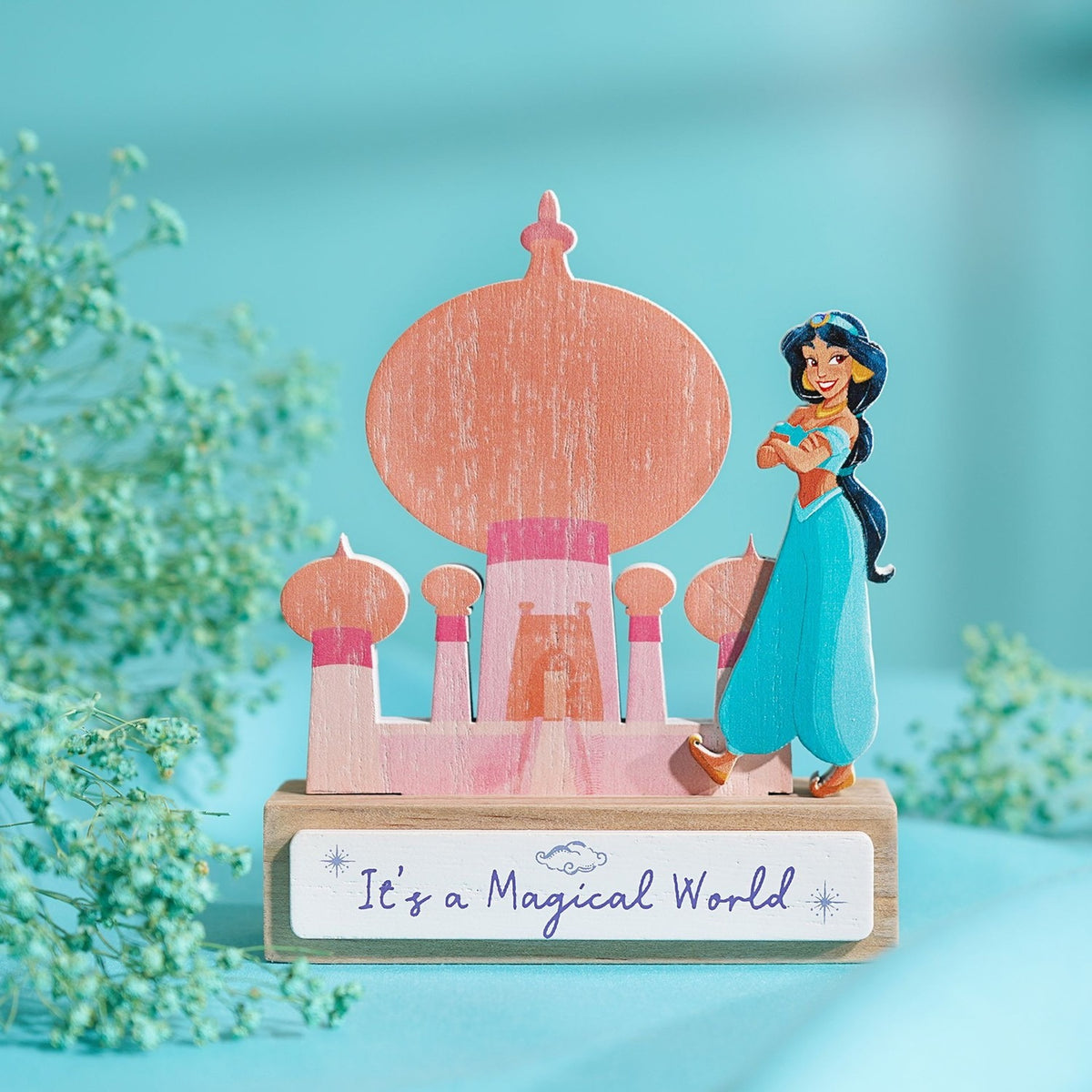 Wooden standing plaque of a pastel coral and pink palace silhouette with onion domes, featuring Princess Jasmine, on a block base reading "It's a Magical World".
