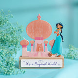 Wooden standing plaque of a pastel coral and pink palace silhouette with onion domes, featuring Princess Jasmine, on a block base reading "It's a Magical World".