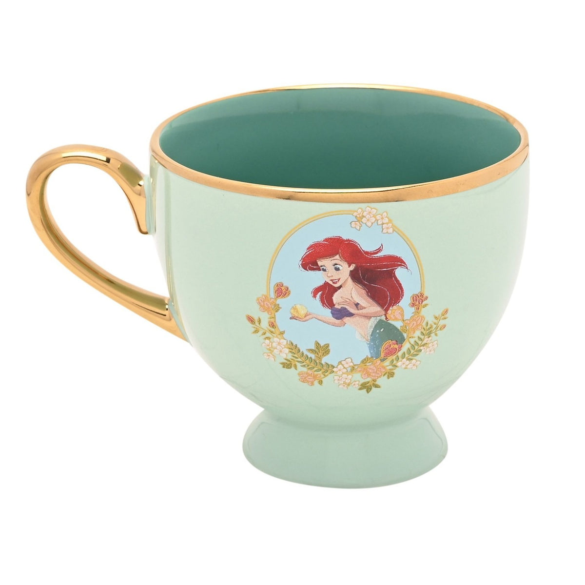 Pastel green porcelain tea cup with gold handle and rim, footed base, and a decal of Ariel holding a shell framed by floral garland, deeper green glaze inside, on a white background.