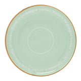 Porcelain saucer from the Pastel Princess Ariel Tea Cup & Saucer set, round pastel green with gold rim and repeated "Dreaming of Another World" text, shown on a white background.