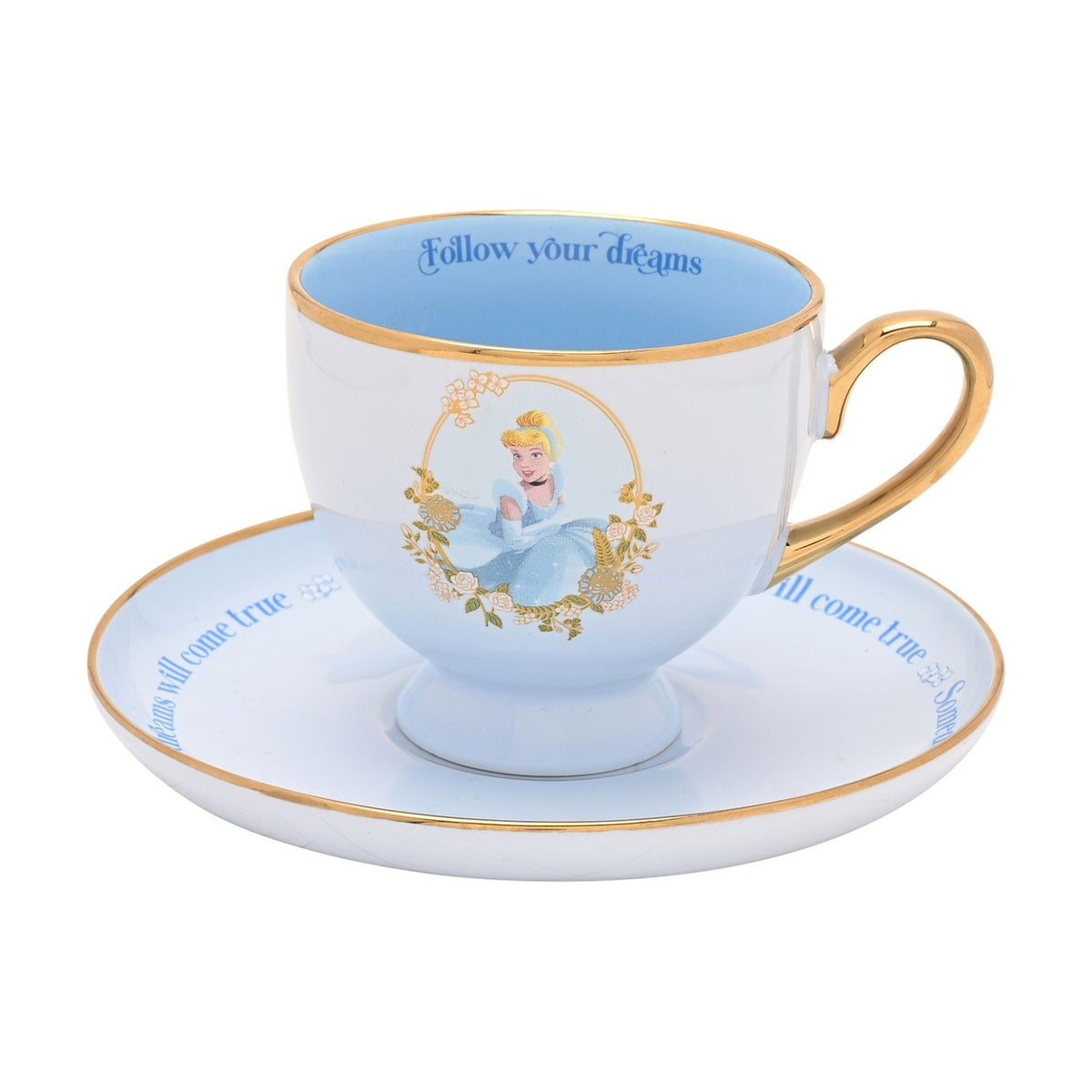 Blue porcelain Cinderella tea cup and saucer with gold trim and handle, rose-framed Cinderella illustration, and Follow your dreams printed inside the rim, on a white background.