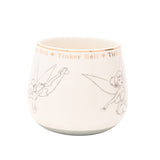 White porcelain Tinker Bell mug with fine grey pencil-style sketches of her in different poses, topped by a gold band repeating her name between small stars on a plain white background.