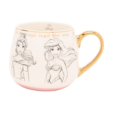 White porcelain mug with sketched grey-pencil princess portraits, a fine gold rim, gold handle, pale blush pink base, and "Let courage lead the way" in gold text.