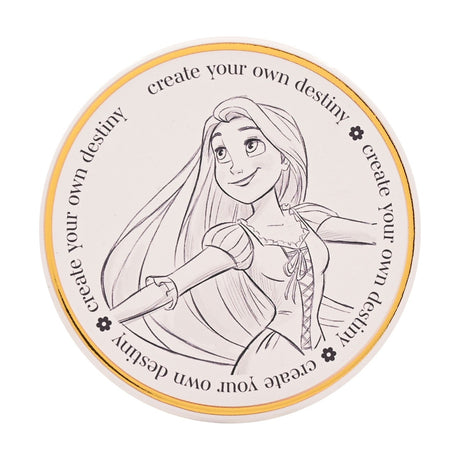 Round white stoneware coaster with a pencil-sketch drawing of Rapunzel, arms outspread, bordered by a gold ring and repeated text "create your own destiny" on a plain background.