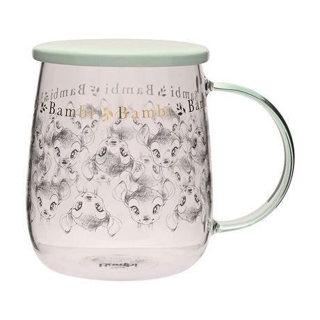 Clear glass mug with a repeating grey sketch of Bambi and gold "Bambi" lettering, rounded shape, pale green lid and handle, shown on a plain white background.