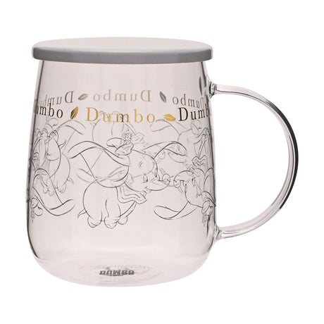 Clear glass mug with grey lid, featuring fine grey line drawings of Dumbo and gold "Dumbo" lettering around the rim, set against a plain white background.