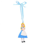 Resin Alice hanging Christmas decoration with blue dress, white apron, yellow hair, and black shoes, suspended from a pale blue ribbon bow against a white background.