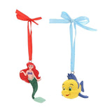 Ariel and Flounder hanging Christmas decorations in resin, Ariel with red hair and green tail on a red ribbon, Flounder yellow with blue fins on a light blue ribbon, plain white background.
