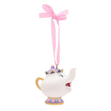 Mrs Potts hanging Christmas tree decoration, a resin white teapot with gold handle, purple lid, gold crown trim and a painted face, on a pink ribbon, plain white background.