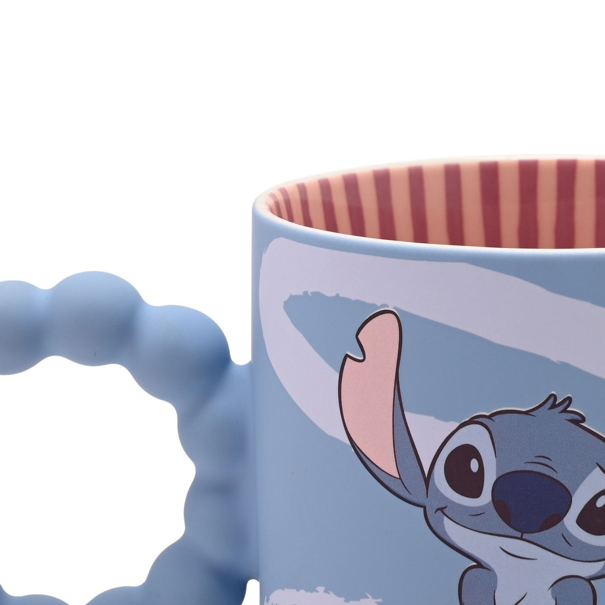 Blue ceramic Stitch mug with chunky bobble handle, white swirl brushstrokes, raised arm and ears, and red-and-cream striped interior, on a white background.