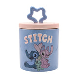 Round stoneware storage jar in blue with "STITCH" in raised pink letters, featuring Stitch and Angel, a pale pink lid, and wavy star knob on a white background.