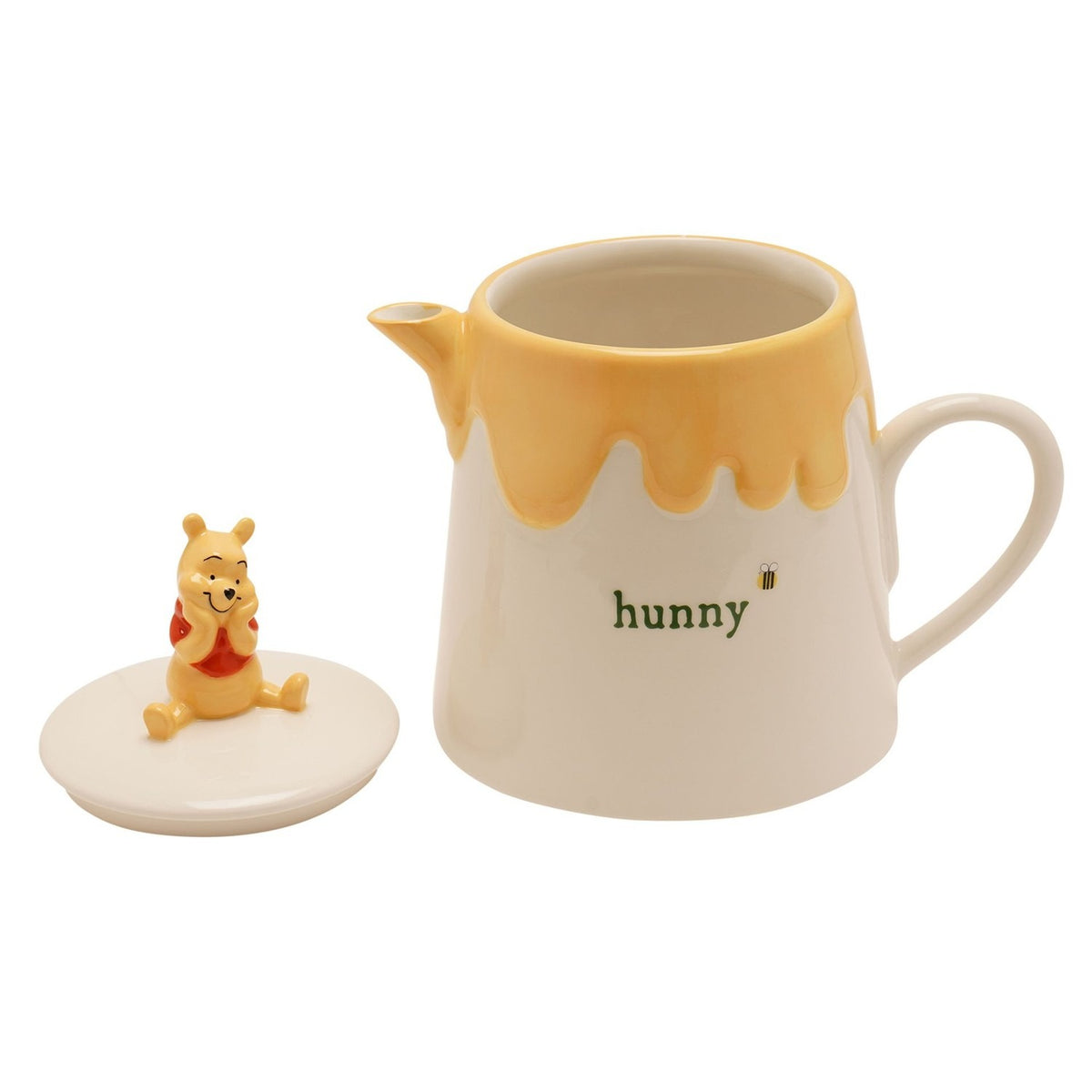 Cream and yellow stoneware teapot shaped like a Winnie the Pooh honey pot, featuring a dripping honey glaze, "hunny" text, bee detail, and a sculpted Pooh figure on the removable lid.
