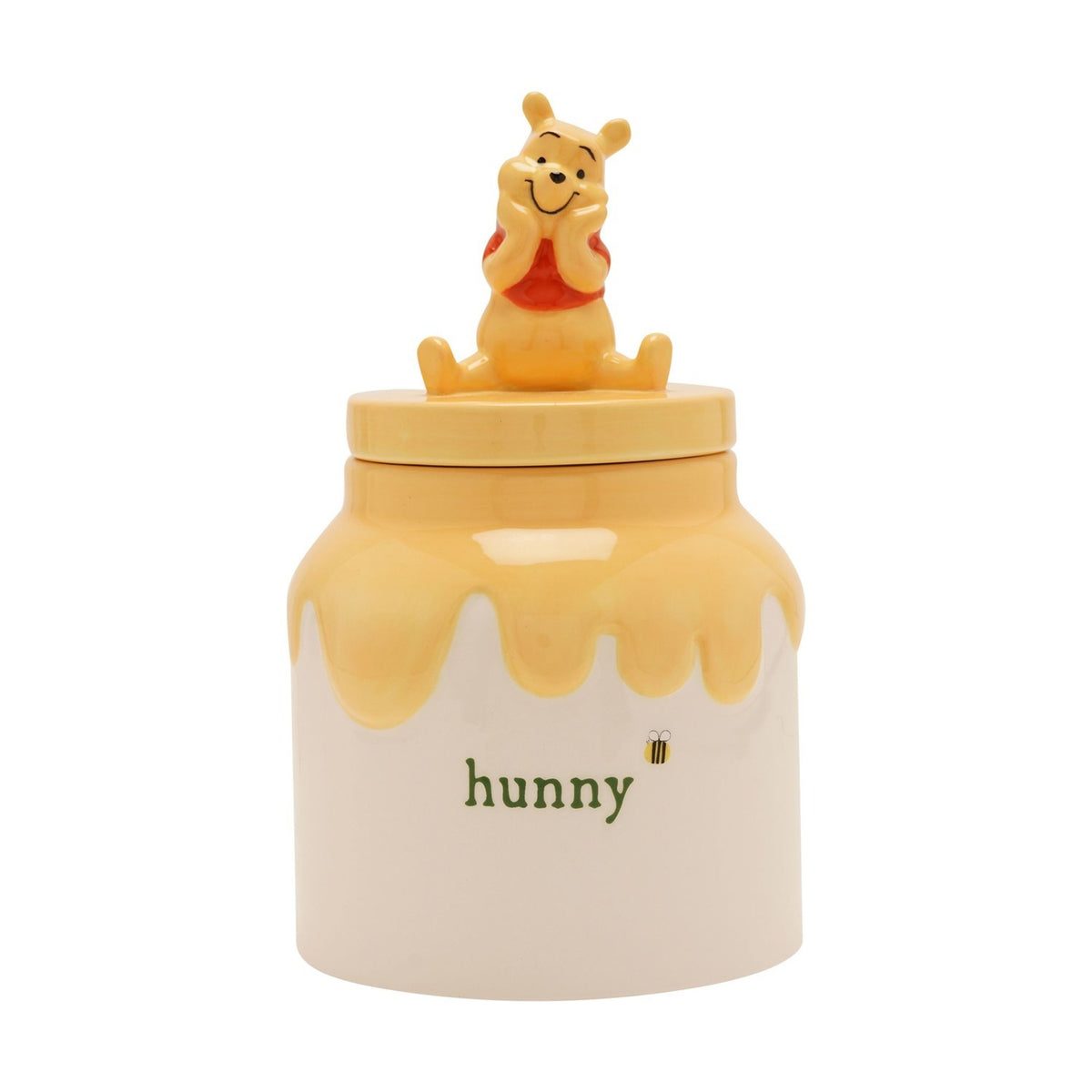 Winnie the Pooh ceramic honey pot storage jar in cream and yellow, with Pooh seated on the lid, "hunny" lettering and a bee motif, on a plain white background.