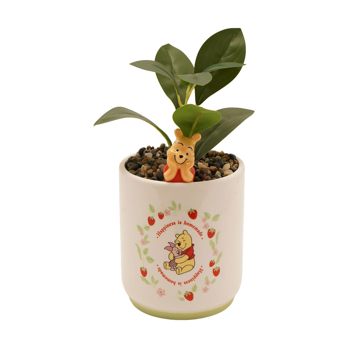 Cream stoneware planter featuring a 3D Winnie the Pooh figure peeking over the rim, printed with Pooh hugging Piglet among strawberries and "Happiness is homemade" text, holding a green plant.