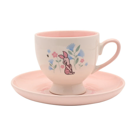 Winnie the Pooh Piglet porcelain cup and saucer, cream footed cup with pink interior and handle printed with Piglet among blue and pink flowers, paired with a matching pink saucer.