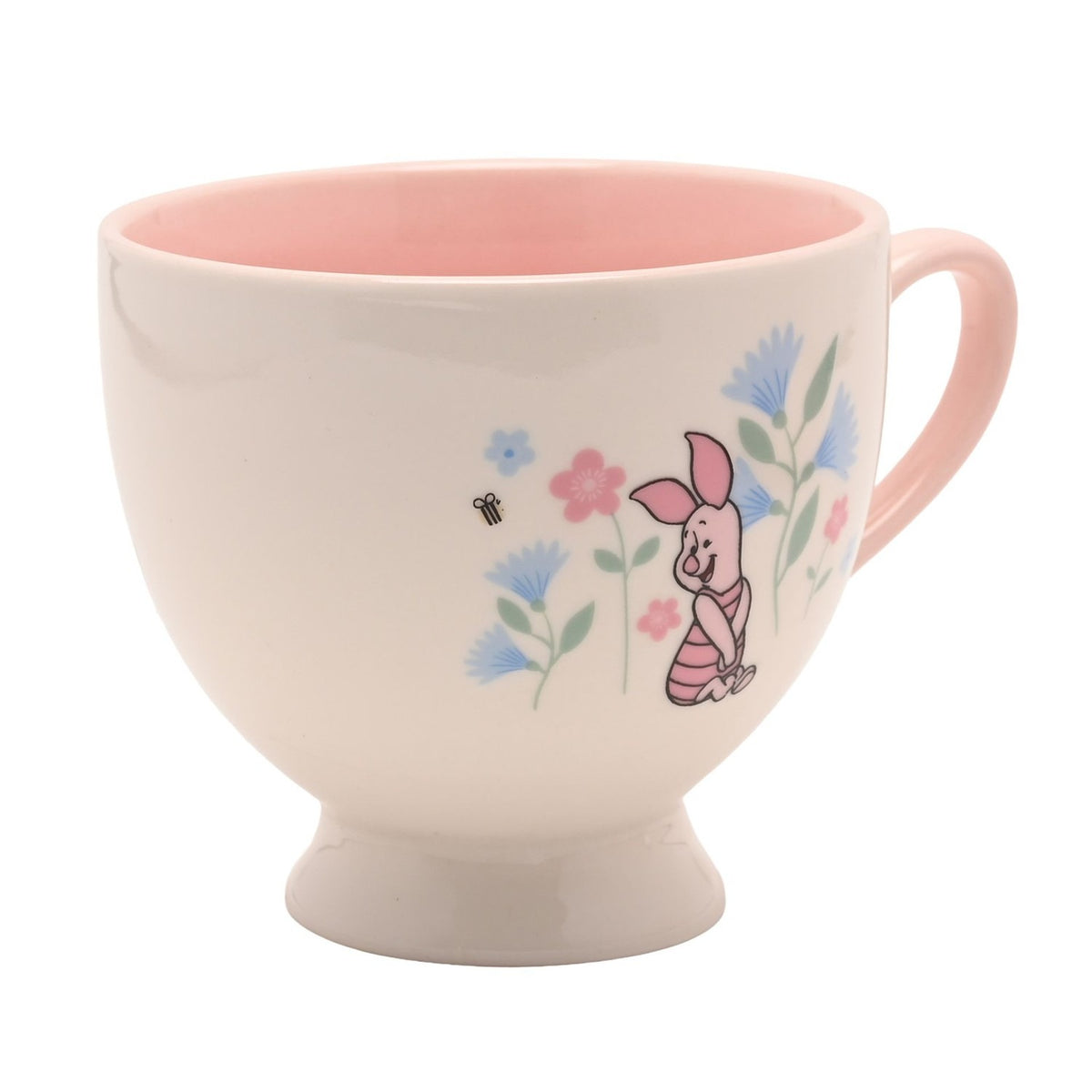 Footed porcelain teacup with pink interior and handle, cream exterior printed with Piglet from Winnie the Pooh amid blue and pink flowers, on a white background.