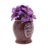 Nightmare Before Christmas Deadly Nightshade Planter in speckled glossy purple, with a lilac label reading "Deadly Night Shade" and faux violet flowers on top, shown on a white background.