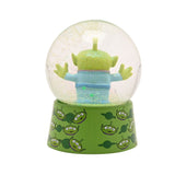 Toy Story Alien glitter plastic snow globe with three-eyed figure, arms raised, inside a clear globe on a green alien-print base, set against a plain white background.
