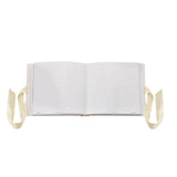 Bambi Baby Photo Album, 6 x 4in, shown open with white plastic sleeve pages and cream ribbon ties on each side, set against a plain white background.